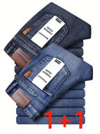 Stapel dunkelblauer herren jeans loose fit straight leg mit braunen lederpatches und weißen etiketten für business casual