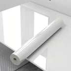 Eine sleek glossy weiße rolle selbstklebende marmor-klebefolie liegt auf spiegelnder oberfläche öl- und wasserdicht für küche und möbel