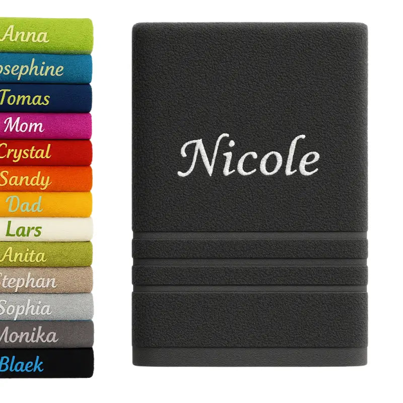 Schwarzes personalisiertes badehandtuch aus 100% baumwolle mit weiß besticktem namen nicole und rippenstruktur