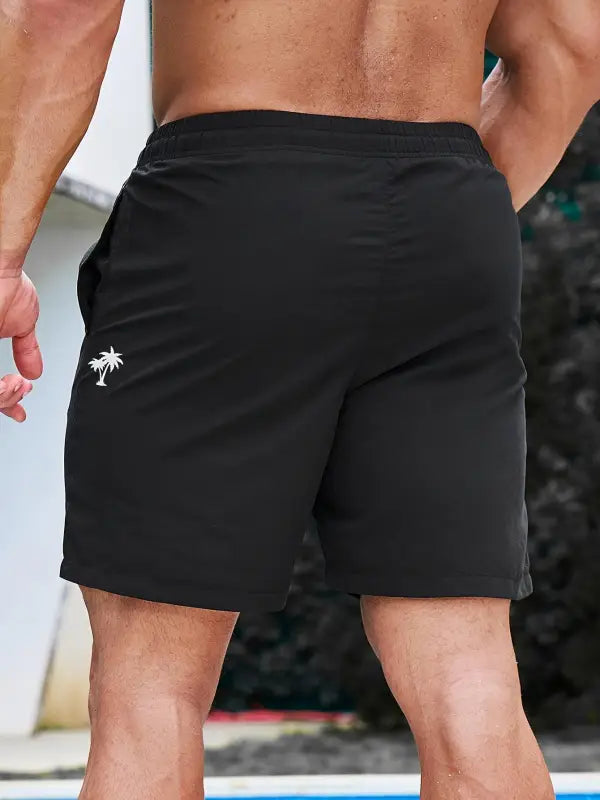 Schwarze herren badeshorts coco beach mit weißem palmbaumlogo auf dem linken bein regular fit