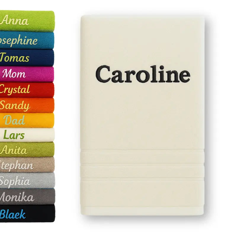 Creamfarbenes personalisiertes badehandtuch aus 100% baumwolle mit name caroline in schwarzem faden bestickt